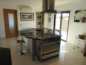 cocina con fogones y encimera en VILLA Casa Eden en Vila Nova de Cacela