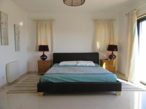 1 dormitorio con 1 cama con 2 mesitas de noche y 2 lámparas en VILLA Casa Eden en Vila Nova de Cacela