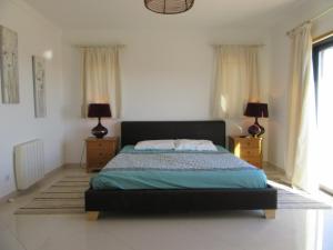 a bedroom with a bed with two night stands and two lamps at VILLA Casa Eden in Vila Nova De Cacela +23 photos