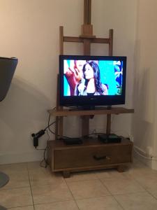 une télévision sur un support en bois avec un écran de télévision dans l'établissement Hyper centre Deauville, à Deauville