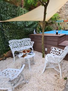 two white chairs and a table and a pool at Chalet los Pinos Constanza in Arroyo Frío