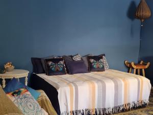 a blue room with a bed with pillows on it at Casa pé na areia in Guarujá