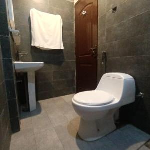 La salle de bains est pourvue de toilettes blanches et d'un lavabo. dans l'établissement Diamond Apart's Dha Karachi, à Karachi
