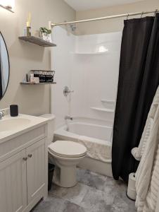 y baño con aseo, lavabo y bañera. en Comfy Champaign 3 Bedroom House, en Champaign