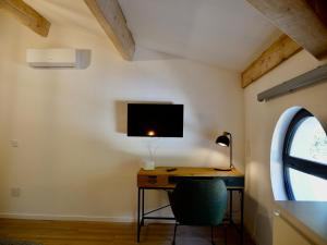 Pokój z biurkiem z monitorem i krzesłem w obiekcie En Vau - Coliving - Mas des Sous Bois w mieście Ventabren