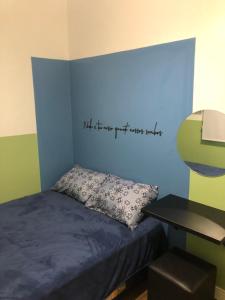 ein Schlafzimmer mit einem Bett mit einer blauen Wand in der Unterkunft Apartamento á 50 mts do mar in Balneário Camboriú