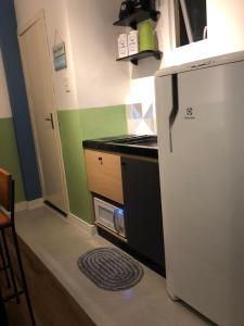 eine kleine Küche mit einem Kühlschrank und einer Theke in der Unterkunft Apartamento á 50 mts do mar in Balneário Camboriú
