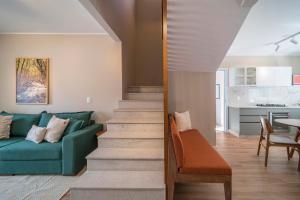 een woonkamer met een groene bank en een tafel bij Casa com 02 dormitórios de casal com jacuzzi aquecida in Bombinhas