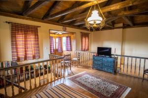 a living room with stairs and a television and a chandelier at villa Melissa in Kostitsi