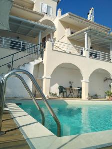 a house with a swimming pool in front of a house at Atena Mare Sea View in Perama