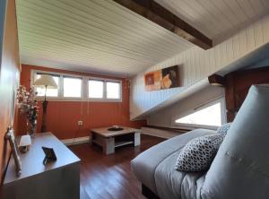 Zimmer im Dachgeschoss mit einem Bett und einem Tisch in der Unterkunft La Petite Maison Neuvecelle - Maison de village in Neuvecelle