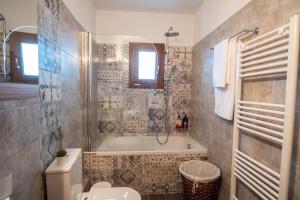 ein Badezimmer mit einer Badewanne, einem WC und einem Waschbecken in der Unterkunft villa Melissa in Kostitsi