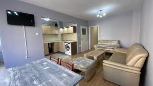 a living room with a couch and a table and a kitchen at J&Z Rooms in Burgas City