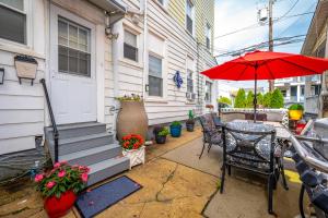 un patio con una mesa y una sombrilla roja en The Allenhurst, en Ocean Grove