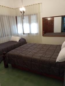 um quarto com 2 camas e uma janela em casa de marta a 50 mts del centro em Villa Carlos Paz