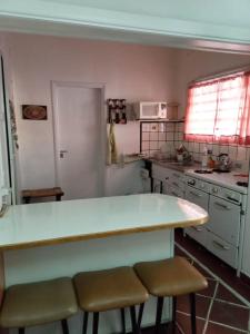 uma cozinha com um balcão e dois bancos em casa de marta a 50 mts del centro em Villa Carlos Paz