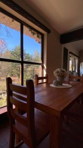 a dining room table with a vase on top of it at El gran roble in La Cumbrecita