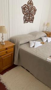 a bedroom with a bed and a table with two lamps at El gran roble in La Cumbrecita