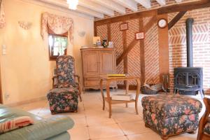 a living room with a table and chairs and a wood stove at Le Clos du Rossignol in Le Tartre