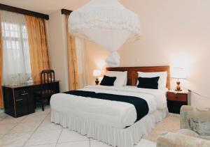 Un dormitorio con una cama grande y una lámpara de araña. en Centre Saint Vincent Pallotti en Kigali