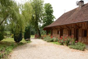 a path next to a building with flowers in front at Le Clos du Rossignol in Le Tartre
