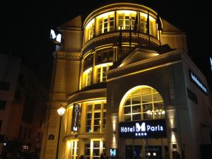 a large building with a sign on it at night at Hôtel Le M in Paris