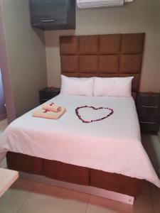 a bed with a heart drawn on it at Sunset View Palace Guest House in Soshanguve