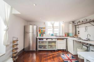 a kitchen with a stainless steel refrigerator and wooden floors at Relais del mar- luxury penthouse with terrace in Naples