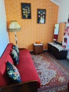 een woonkamer met een rode bank en een lamp bij Stylowe PRLove in Rogowo