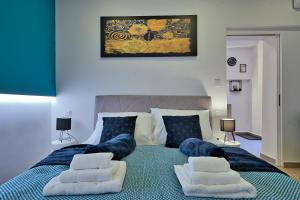 a bedroom with a large bed with blue pillows at Aurea City Center Apartment Zagreb in Zagreb