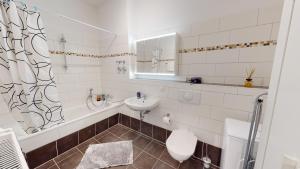 ein weißes Bad mit einem Waschbecken und einem WC in der Unterkunft SweetHome - Business-Apartment mit Küche, Terrasse, Stellplatz in Magdeburg