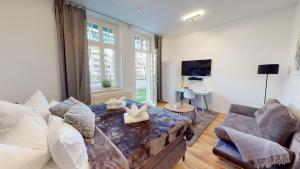 ein Wohnzimmer mit einem Sofa und einem Tisch in der Unterkunft SweetHome - Business-Apartment mit Küche, Terrasse, Stellplatz in Magdeburg