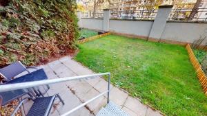 einen Garten mit Stühlen und einen Rasen mit einem Zaun in der Unterkunft SweetHome - Business-Apartment mit Küche, Terrasse, Stellplatz in Magdeburg