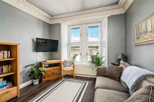 uma sala de estar com um sofá e uma televisão em Broughty Ferry Riverview Apt -3 bedroom -Sleeps 7 em Broughty Ferry