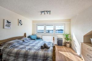 a bedroom with a large bed and two windows at Broughty Ferry Riverview Apt -3 bedroom -Sleeps 7 in Broughty Ferry