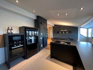 a kitchen with a black refrigerator and a counter top at Luxus Loft über den Dächern von Roding in Roding