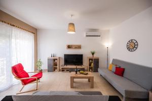 a living room with a couch and a tv at Katerina's House in Afantou