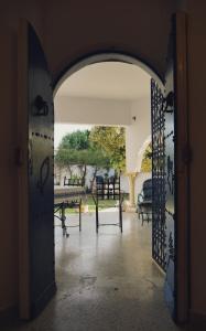 een open deur naar een patio met tafels en stoelen bij Dar Balti - Hammamet Nord in Hammamet Nord