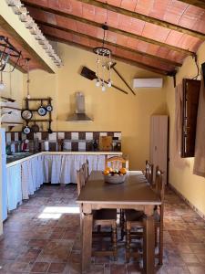 eine Küche mit einem Holztisch mit Stühlen und eine Küche mit einer Theke in der Unterkunft Cortijo El Nevazo in Fuentes de Cesna