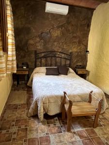 a bedroom with a bed and a bench in it at Cortijo El Nevazo in Fuentes de Cesna +41 photos