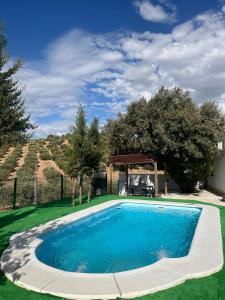 een zwembad in een tuin met een tuinhuisje bij Cortijo El Nevazo in Fuentes de Cesna