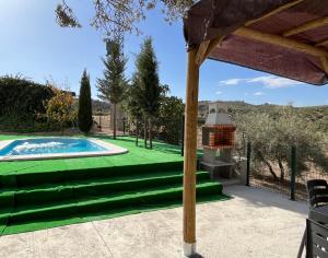 een achtertuin met een zwembad en een groen gazon bij Cortijo El Nevazo in Fuentes de Cesna