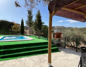 a backyard with a pool and a green lawn at Cortijo El Nevazo in Fuentes de Cesna