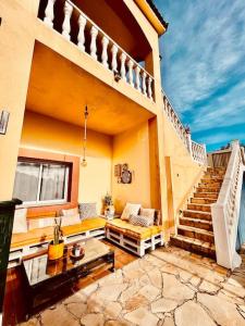 a living room with a staircase and a couch at Casa Maca, espectacular casa con piscina y vistas in Olivella
