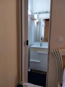 une salle de bains avec un lavabo blanc et un miroir dans l'établissement La petite maison, spacieuse, avec jardin / parking, à Sainte-Rose 26 autres photos