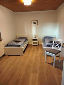 a room with two beds and a chair in it at FeWo beim Schmetterlings Park in Buchholz in der Nordheide