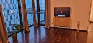 a living room with a television and large windows at Homey Apartments Harbor Suite - Parking Two Bathrooms Netflix Sea view in Bremerhaven