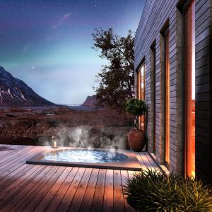 una bañera de hidromasaje en una terraza junto a una casa en NEW! Luxury Cabin in beautiful Lofoten, en Kleppstad