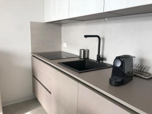 een keuken met een wastafel en een telefoon op een aanrecht bij Art Vista Lake Como in Nesso