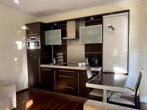 uma cozinha com armários castanhos e uma mesa num quarto em Apartament 2 pokojowy 5min od Krupówek z garażem em Zakopane